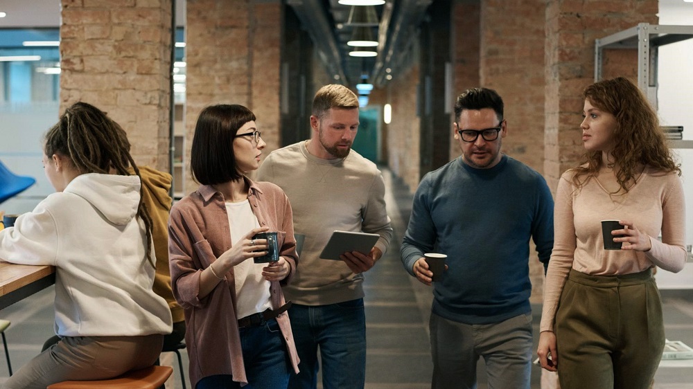 People walking and talking at work with a coffee.