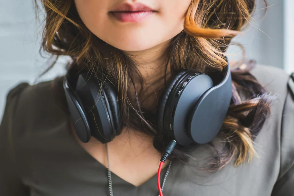 A woman with black headphones around her neck