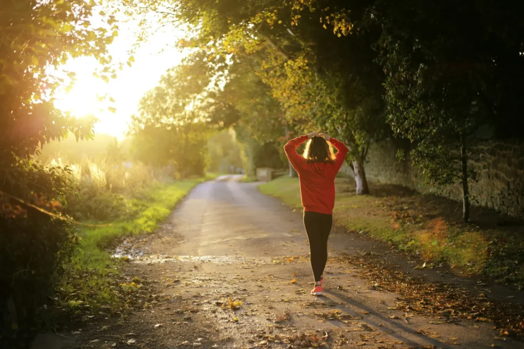 Woman walking towards a sunset