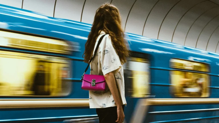 A woman stood next to a moving train.