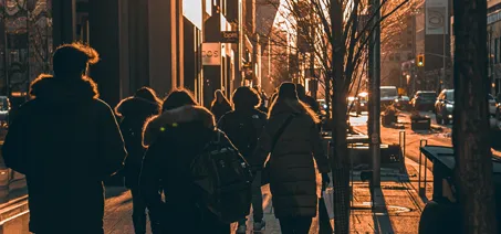 People walking in the sunset in a city